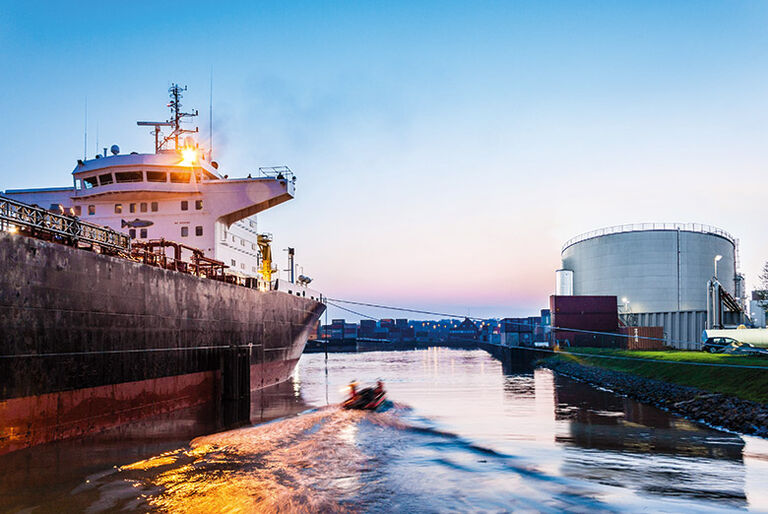 [Translate to English:] Schiff im Hafen gegenüber einem Tanklager